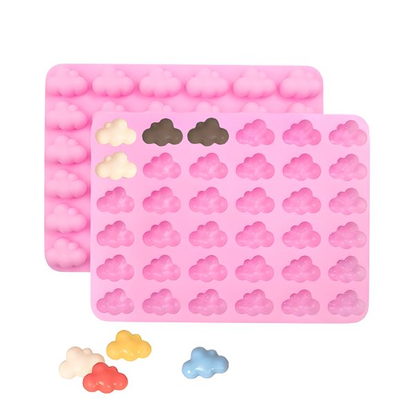 Two pink silicone moulds shaped like clouds are shown in the image. One mould has several rows of small cloud shapes, while the other has fewer clouds. Also featured are a few completed cloud-shaped items in various colors, including yellow, light blue, and shades of white and gray, lying next to the moulds. The overall composition emphasizes the playful and whimsical design of the moulds.
