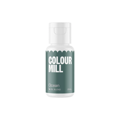 White bottle of "Colour Mill" oil blend labeled "Ocean," in white text over a deep teal background. Bottle is centered on a black backdrop.