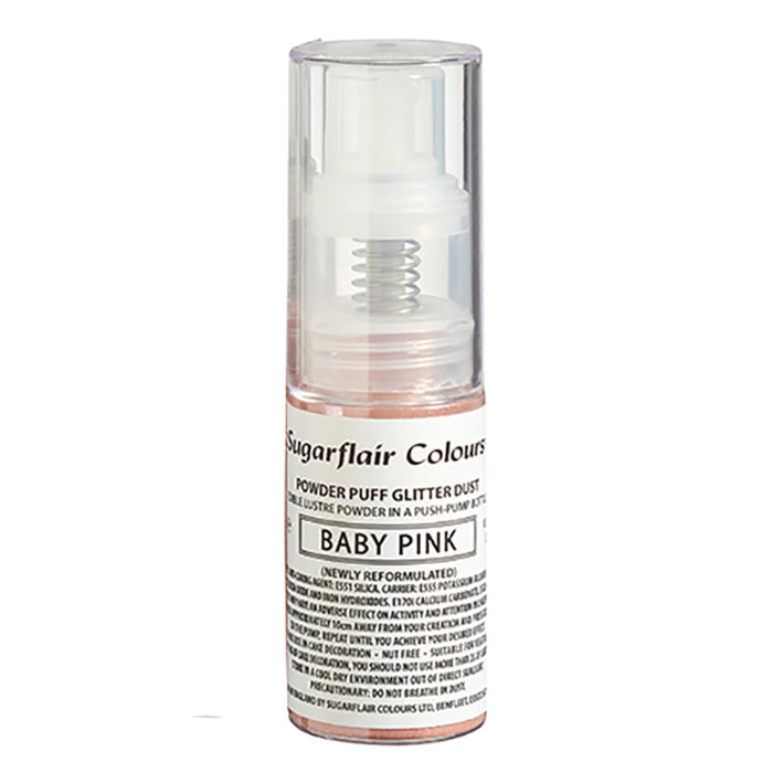 The image shows a 30ml bottle of Sugarflair Edible Glitter Dust Spray in baby pink. The bottle is clear with a push-pump nozzle at the top. The label on the bottle includes the product name "Sugarflair Colours" and describes the contents as "Powder Puff Glitter Dust" with "BABY PINK" prominently displayed. The text also mentions that the product is newly reformulated. The glitter dust appears to have a shimmering, light pink color.