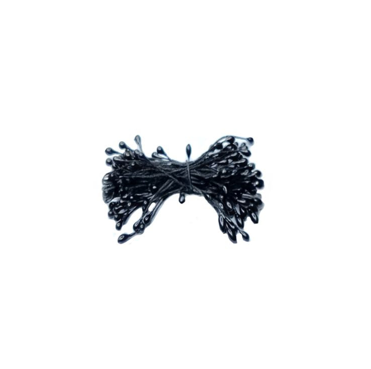 A bundle of glossy black bobby pins is tightly wrapped together, with each pin featuring a small rounded tip. The image has a minimalist, organized feel.