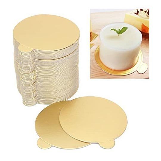 A stack of gold-colored round cake boards, each measuring 8cm in diameter, is shown with two individual boards in the foreground. In the background, there is an image of a white dessert placed on a gold board, garnished with a small mint leaf. The overall presentation demonstrates the product&