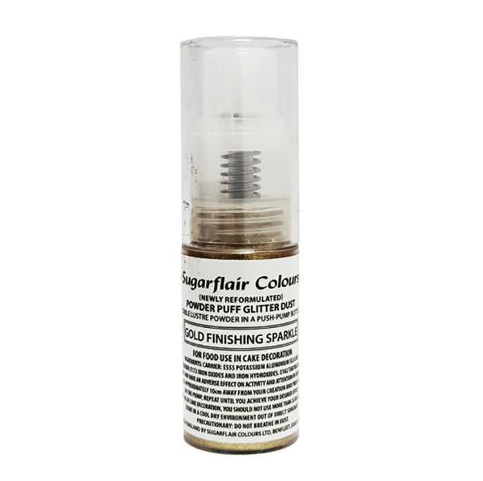 The image shows a cylindrical spray container of Sugarflair edible glitter dust. The container is transparent with a gold-colored powder inside and features a push-pump nozzle at the top. The label on the container indicates that it is a re-formulated product labeled &quot;Gold Finishing Sparkle,&quot; specifically designed for cake decoration. The text includes warnings and instructions for food use. The overall size is small, typically suitable for easy handling during use.