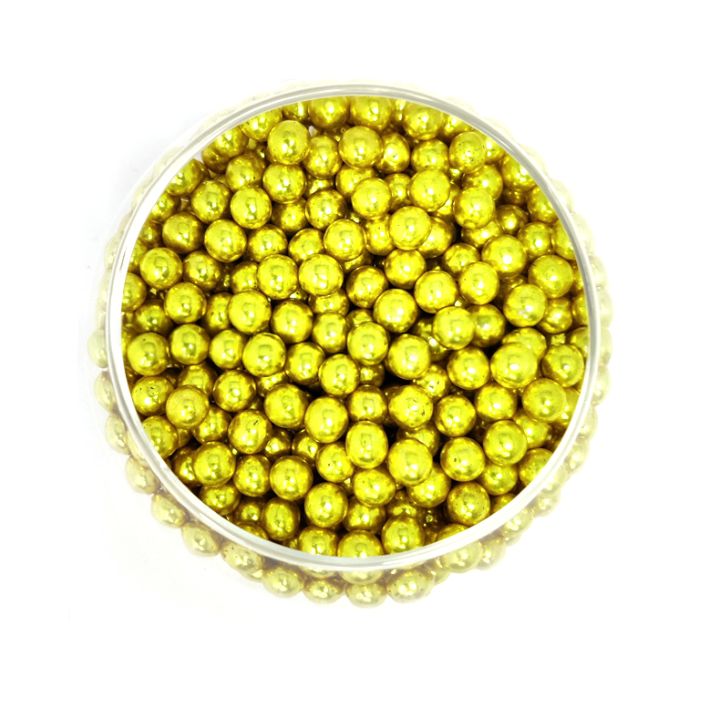 A round container filled with shiny, metallic gold beads, densely packed and reflecting light. The bright, cheerful tone suggests festivity.