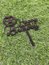 A cake topper featuring the phrase "Happy Birthday" in an elegant script. It is designed with a soccer ball at the beginning of the text. The topper is placed on a green grass-like background, emphasizing its decorative purpose for a birthday celebration.