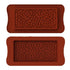 The image shows two silicone moulds for making chocolate bars, both designed with a pattern of small hearts. The moulds are rectangular in shape, with rounded edges and a textured heart design covering the surface. The top mould is positioned above the bottom mould, and both have a similar heart pattern, creating a decorative effect for the chocolate bars. The colour of the moulds is a rich, reddish-brown.