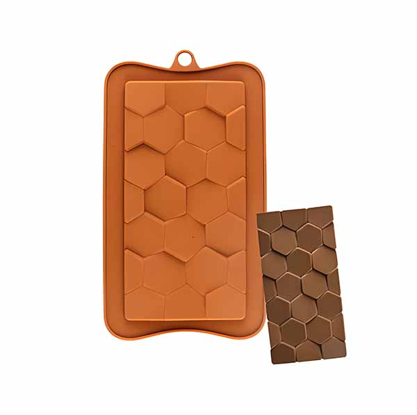 A silicone mould for making hexagon-shaped chocolate bars. The mould is rectangular and features multiple hexagon cavities. Next to it is a finished chocolate piece shaped like the mould, showcasing a similar hexagon pattern. The mould is orange, and the chocolate is a darker brown color.