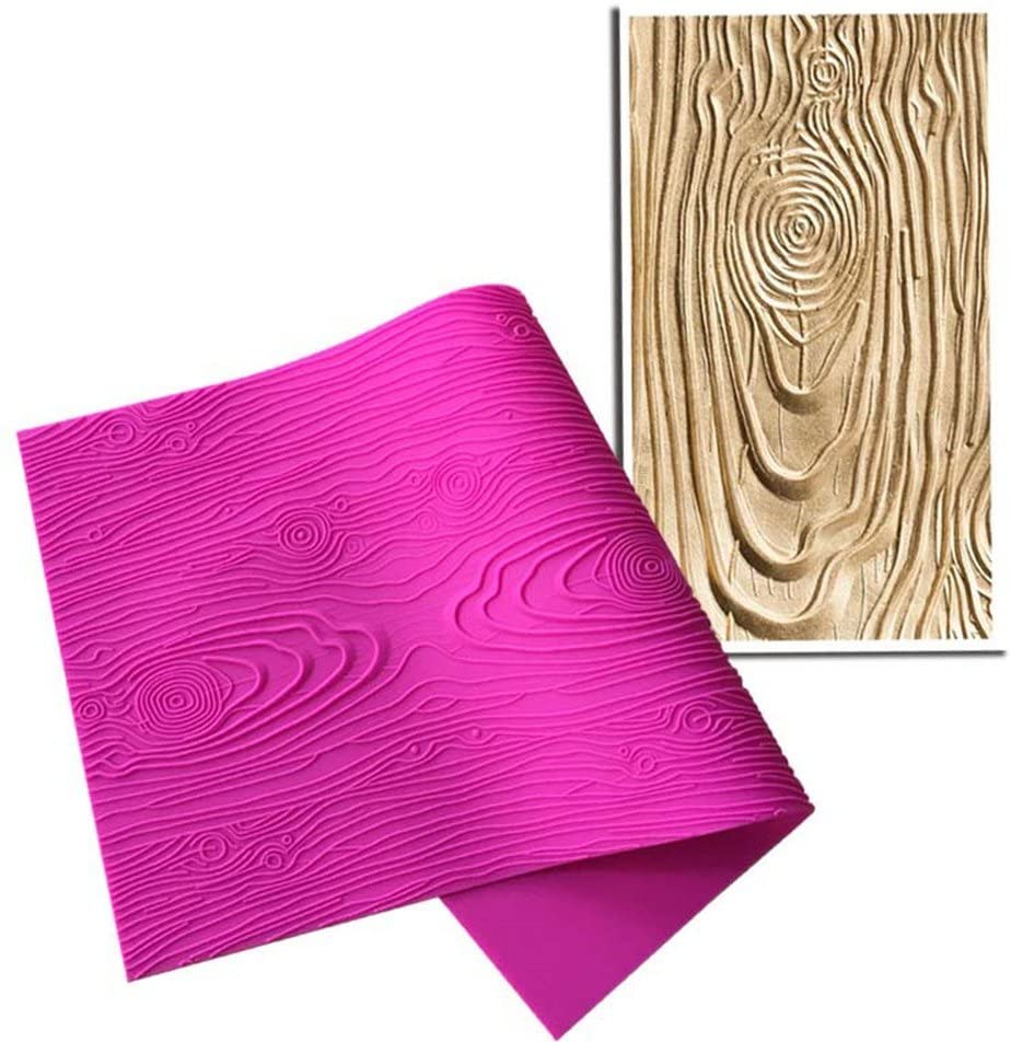 An image displaying a pink silicone mat designed for creating woodgrain impressions on fondant. The mat features a textured surface resembling wood grain patterns, including swirls and rings. Next to the mat is an example of a fondant piece that has been pressed with the mat, resulting in a beige-colored fondant that showcases the wood grain design.