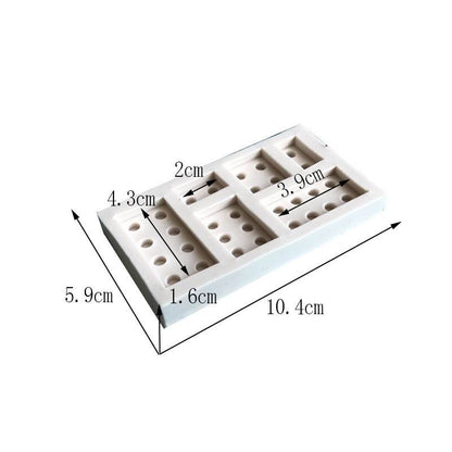 A white silicone mold shaped like Lego bricks, measuring 10.4 cm in length and 5.9 cm in width. The mold features multiple brick designs with varying sizes and holes, with dimensions labeled: 2 cm, 4.3 cm, 3.9 cm, and 1.6 cm.