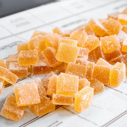 A collection of orange gummy bears stacked together on a white background.
