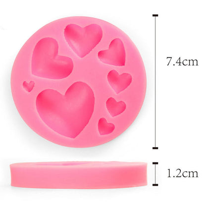 A pink silicone mould shaped like a circle with multiple heart cavities of varying sizes. The mould measures 7.4 cm in diameter and 1.2 cm in height.