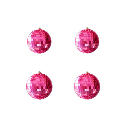  Four pink disco balls arranged on a white background, reflecting light and creating a vibrant, festive atmosphere.