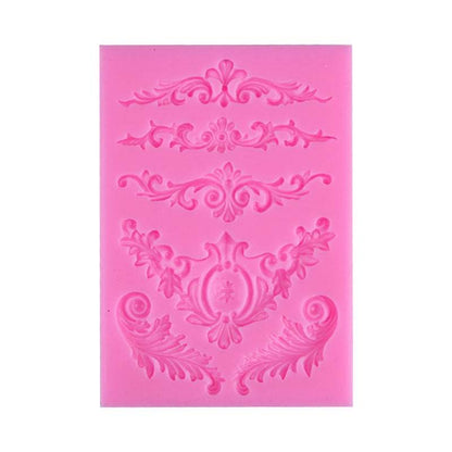 A pink decorative silicone mould featuring intricate patterns. The mould contains multiple designs, including floral and scrollwork motifs, arranged in horizontal bands. Each design varies in shape and detail, showcasing elegant curves and embellishments suitable for crafting or baking projects.
