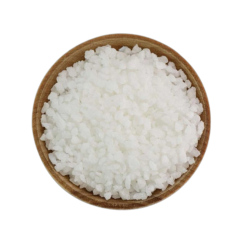Wooden bowl filled with white pearl sugar grains on a white background