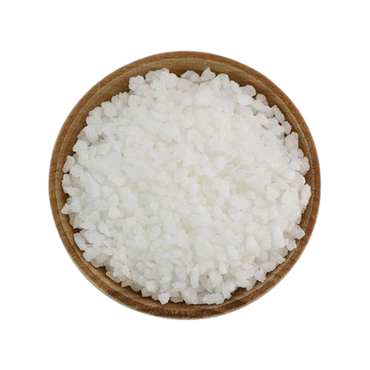 Wooden bowl filled with white pearl sugar grains on a white background