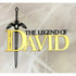 A cake topper features a decorative design with the words "THE LEGEND OF DAVID" in bold fonts. The word "DAVID" is notably larger and in gold, while the rest of the text is black. Above the text, there is a stylized sword graphic. The background appears to have a light, marbled texture.