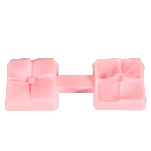 A pink silicone mold designed for making flower petal press cakes. The mold features two flower shapes with detailed petal designs and is connected by a central handle.