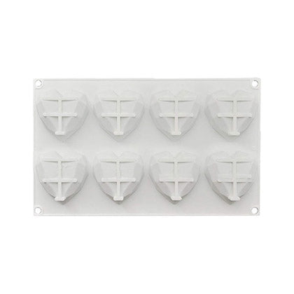 An 8 cavity mini piñata heart mold is depicted. The mold features a rectangular base with eight heart-shaped cavities, each with a cross pattern in the center. The mold is white and is designed for creating mini piñata shapes.