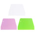 Three plastic dough scrapers displayed in a stacked arrangement. The top scraper is white, the middle scraper is light pink, and the bottom scraper is bright green. Each scraper has a rounded corner and features a small hole in one corner for hanging or storage.