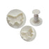 A set of three butterfly-shaped plunger cutters in white plastic. The set includes two circular cutters with raised butterfly designs and a plunger handle used for pressing out the shapes. The cutters are intricately detailed and vary slightly in size.
