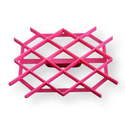 An image of a pink plastic cookie cutter designed to create quilt pattern designs on cookies. The cutter features a grid-like structure with horizontal and vertical lines intersecting to form a diamond design. It has a flat base and a raised edge for easy handling. The background is plain, emphasizing the cutter&