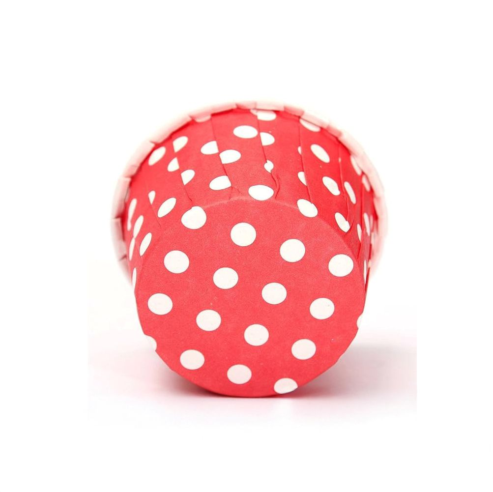 Red cupcake liner with white polka dots on a white background