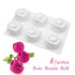 A white silicone mold shaped like rose flowers, featuring six cavities for creating rose-shaped desserts. Three vibrant pink rose desserts with green leaves are placed beside the mold. The text "6 Cavities Rose Mousse Mold" is displayed in a playful font.