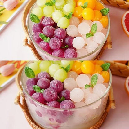 Colorful fruit ice balls in a glass bowl with a woven coaster on a light pink background.