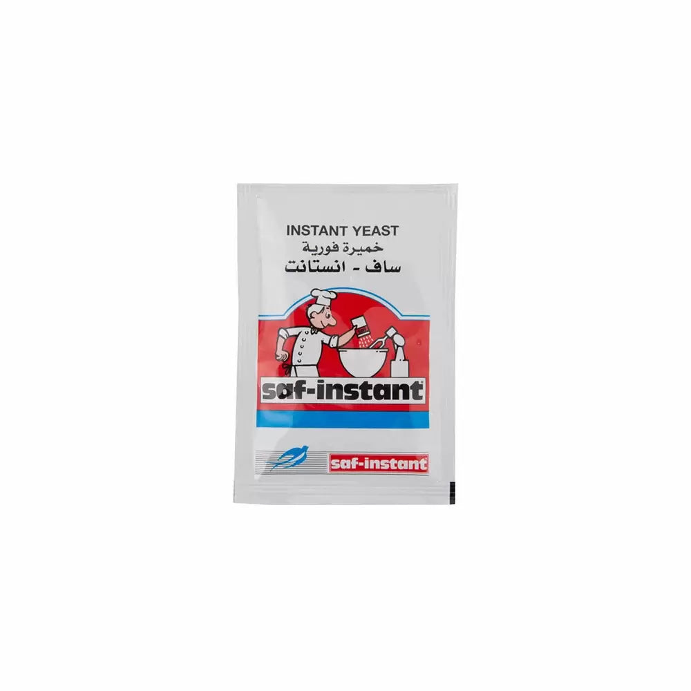 Small packet of Saf-Instant instant yeast with a red and blue design. Illustration of a baker mixing ingredients is on the front, evoking a sense of culinary creativity.