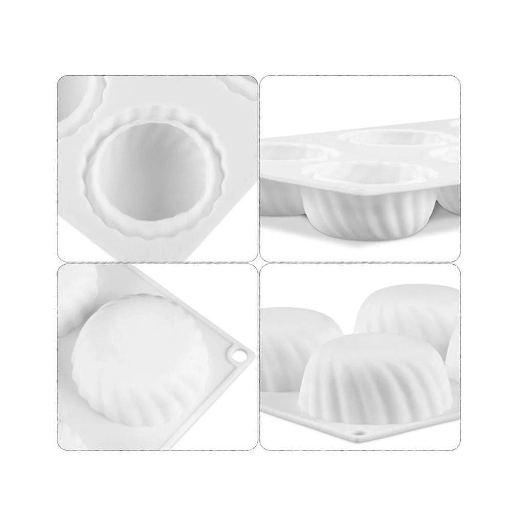 Four white cupcakes arranged in a tray, featuring different decorative frostings and embellishments.