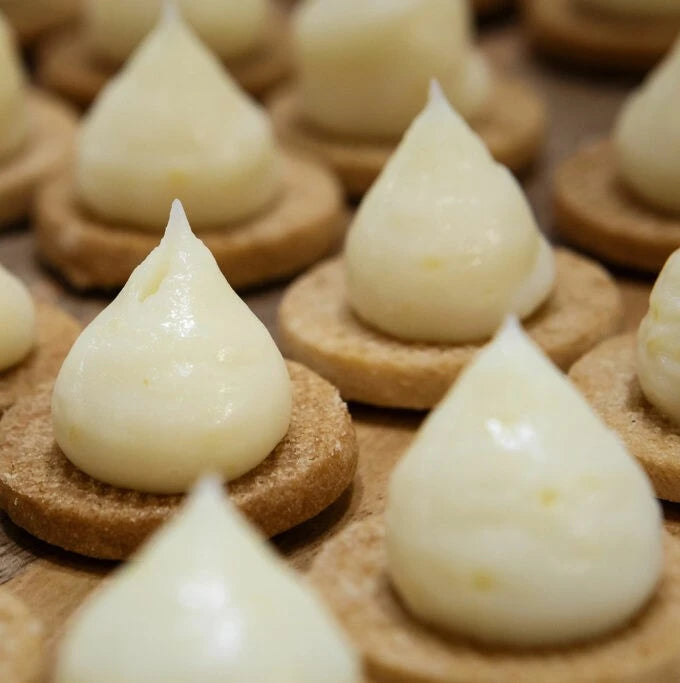 A detailed view of a plate of white cookies, highlighting their smooth surface and inviting presentation.