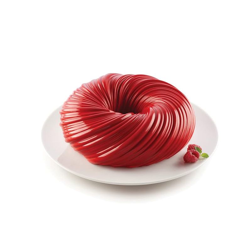 A glossy red dessert with a spiral design on a white plate, accompanied by fresh raspberries and mint leaves, conveying elegance and indulgence.