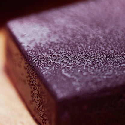  Close-up of a purple soap block, showcasing its smooth texture and vibrant color against a neutral background.