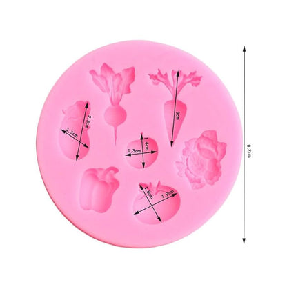 Pink circular silicone mold featuring various vegetable shapes, including a carrot, beet, and pepper, each with measurements. Mold has a playful tone.